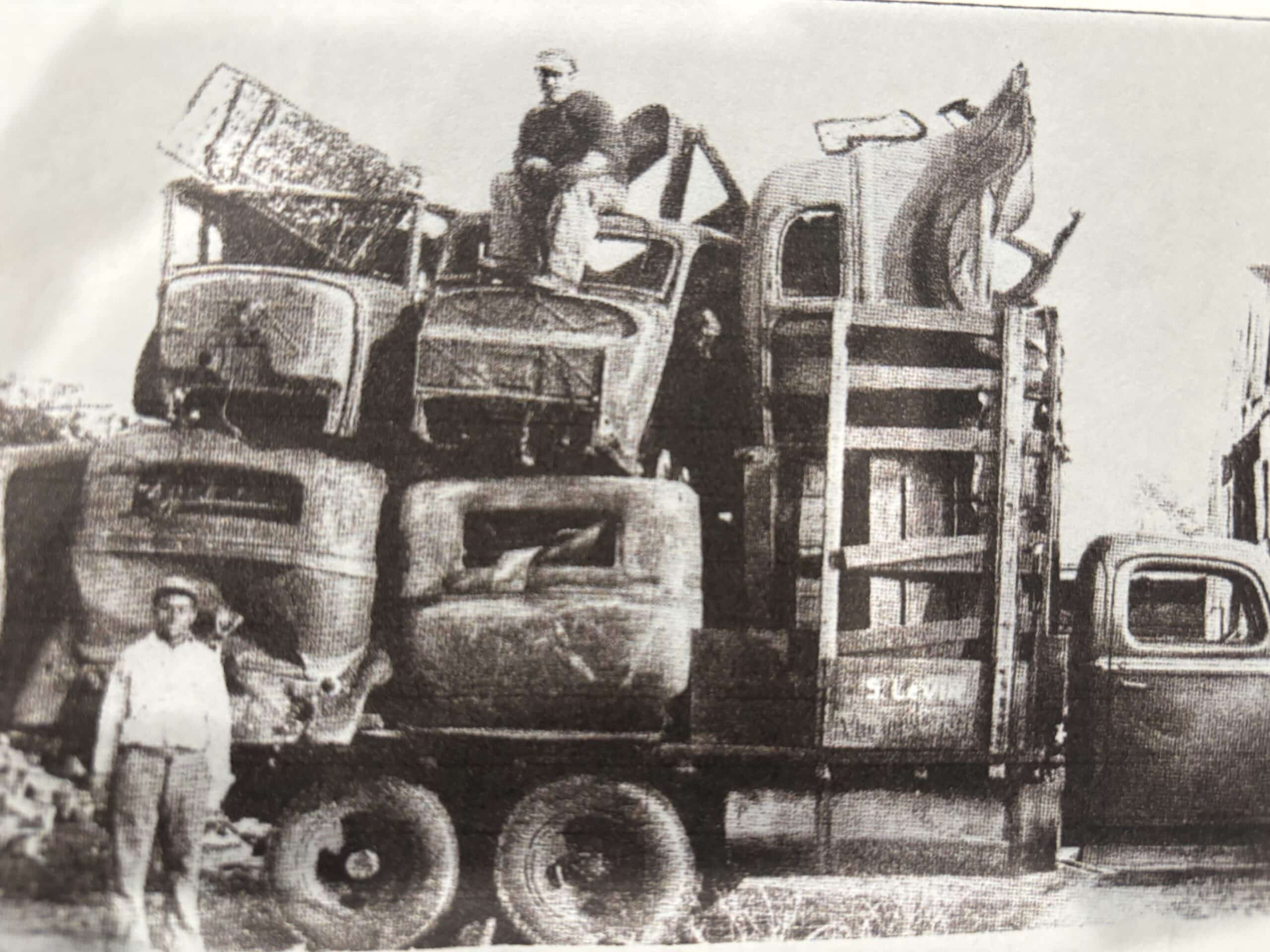 Early-1900s Levin family scrap-hauling truck in South Jersey — "S. LEVIN" lettered on the door, two crew members posed with the load.